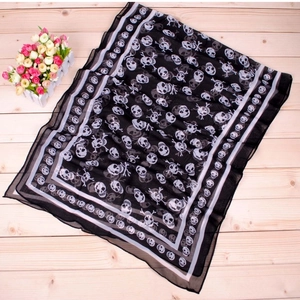 Detail shot of lightweight black chiffon scarf featuring classic white skull and crossbones print