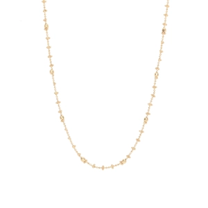 Detail shot of dainty gold chain necklace with metallic spheres and tiny beads