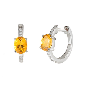 Macro shot of silver earrings featuring oval orange zircon and micro-pave diamond accents