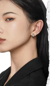 Close-up of textured sterling silver hoop earrings worn by a model with a minimalist style