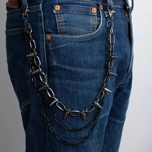 Close-up of three-layer dark gunmetal pants chain with punk metal cone spikes on jeans