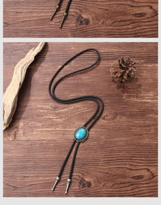 Detail of vintage turquoise bolo tie with silver engraved frame on a rustic wooden surface