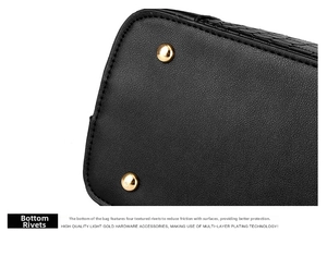 Macro detail of black leather bag base with four protective light gold metal studs