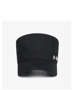 Detail of star-shaped metal emblem and durable cotton twill fabric on black military cap
