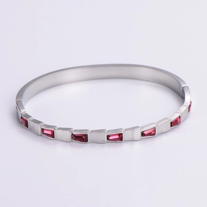 Detail of silver stainless steel bangle with trapezoidal red ruby stone inlay
