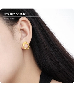Close-up of elegant gold wave stud earring with pavé diamonds on model ear