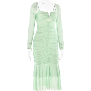 Detail of light green mesh dress showing pleated texture, waist cutout and mermaid hem