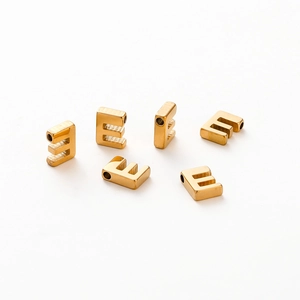 Close-up of gold plated letter E charms with 1.8mm holes for DIY jewelry making