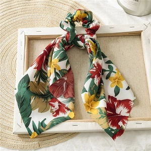 Detail of floral satin scrunchie with long ribbons on a minimalist wood canvas frame