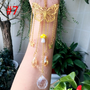 Detail of golden butterfly suncatcher with yellow mushroom and faceted crystal ball