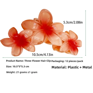 Detailopname van een grote bloem haarklem met drie oranje gradiënt bloembladen