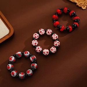 Bracelet de perles coccinelle et cœur en trois pièces sur fond en cuir