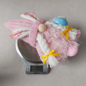 Detailed view of pink Easter gnome plush weighing 157 grams on a digital scale