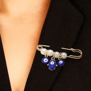 Détail de la main de Fatma et des yeux maléfiques sur un revers de costume noir