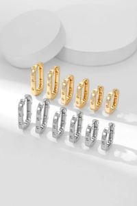 Close-up of square zircon hoop earrings in polished gold and silver plating