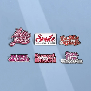 Pink enamel pin set with humorous quotes like hell yeah and smile on blue background