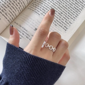 925 sterling silver hollow chain ring worn by a model against a vintage book background