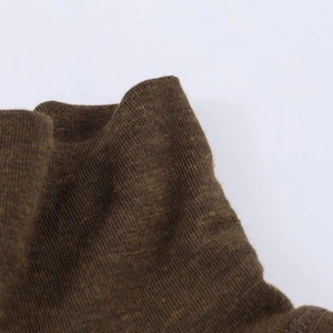 Gros plan détaillé sur la texture fine en tricot et les coutures marron de ce t-shirt ajusté