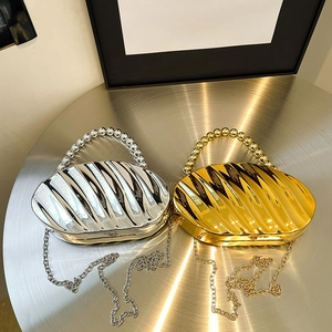 Shell shaped acrylic clutch bag with pearl handle and metal chain in gold and silver