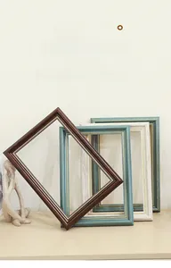 Close-up of stacked vintage oil painting frames with beaded inner trim in multiple colors