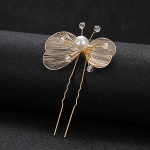 Detail of a hollow golden flower bridal hair pin with fine wirework and pearl