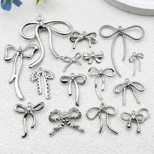 Polished silver alloy bow pendants in various designs for DIY jewelry making