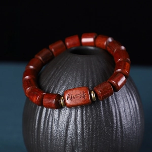 Détail d'un bracelet en bois de santal avec une perle cylindrique gravée Tongxin Yuan