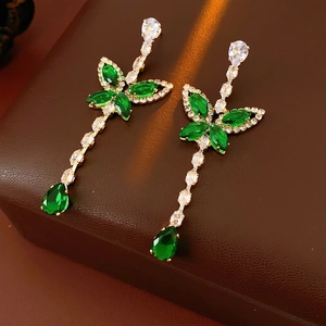 Emerald butterfly drop earrings with cubic zirconia chain on brown leather