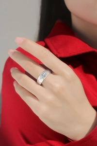 Close-up of 925 sterling silver moissanite ring worn by a male model with red background
