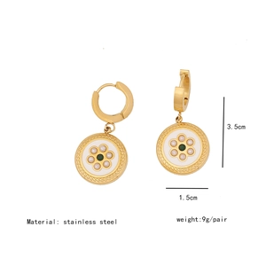 Detailed view of stainless steel flower earrings with pearls and green gemstones