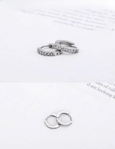 Macro shot of silver hip hop hoop earrings with clear rhinestones and hinge closure