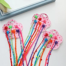 Detailed view of colorful braided hair extensions for girls with beads and clips