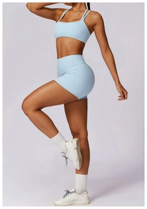 Detail of light blue quick-dry yoga set showing high-waist shorts and strappy sports bra