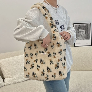 Detail of plush floral tote bag in cream sherpa with green flower patterns and logo