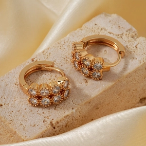 Goldene runde Creolen mit Mikro-Zirkonia auf eleganter champagnerfarbener Seide