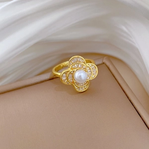 Detail of gold flower ring with center white pearl and sparkling pavé zircon stones