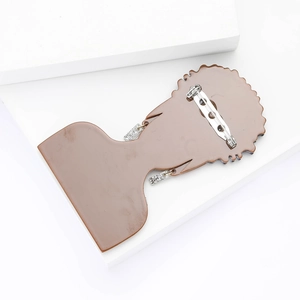 Detailed back view of acrylic brooch featuring a silver safety pin on a white platform
