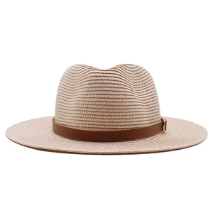 Detailed close-up of woven panama straw hat with brown leather band and metal buckle