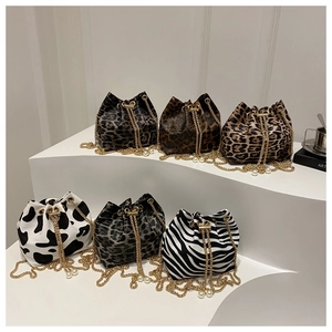 Close-up of animal print bucket bags with gold chains and pearl drawstring charms
