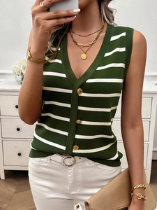 Dettaglio del gilet in maglia a righe verdi e bianche con bottoni dorati e scollo a V