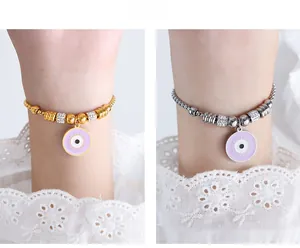 Detail of beaded evil eye bracelets in gold and silver with purple enamel and pavé spacers