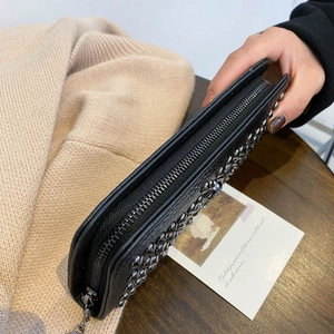 Detailansicht der schwarzen Geldbörse mit silbernen Nieten auf einem Holztisch gehalten