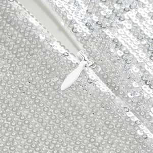 Close-up of silver sequins dress featuring a hidden white zipper and fine sewing craft