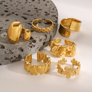Vintage golden stainless steel heart and floral ring set on natural stone background