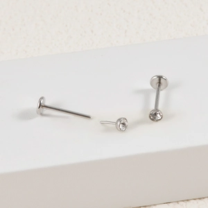 Macro shot of silver stainless steel lip studs with clear round zirconia crystals