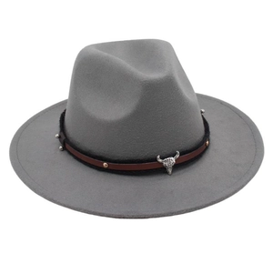 Detail of silver bull head buckle on grey felt fedora hat with studded leather band