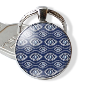 Macro view of blue evil eye keychain with silver polished metal rim and keyring