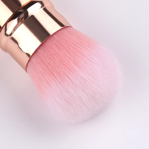 Close-up of soft pink gradient bristles and rose gold ferrule of a makeup brush