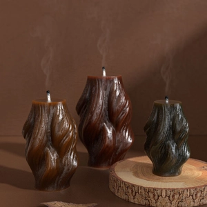 Artistic wave spiral aromatherapy candles in brown and green earth tones on wood
