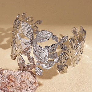 Detail of silver hollow flower cuff bracelet with wide metallic floral pattern